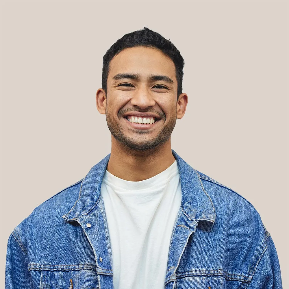 Smiling man in a white t-shirt sharing his successful driving test experience.